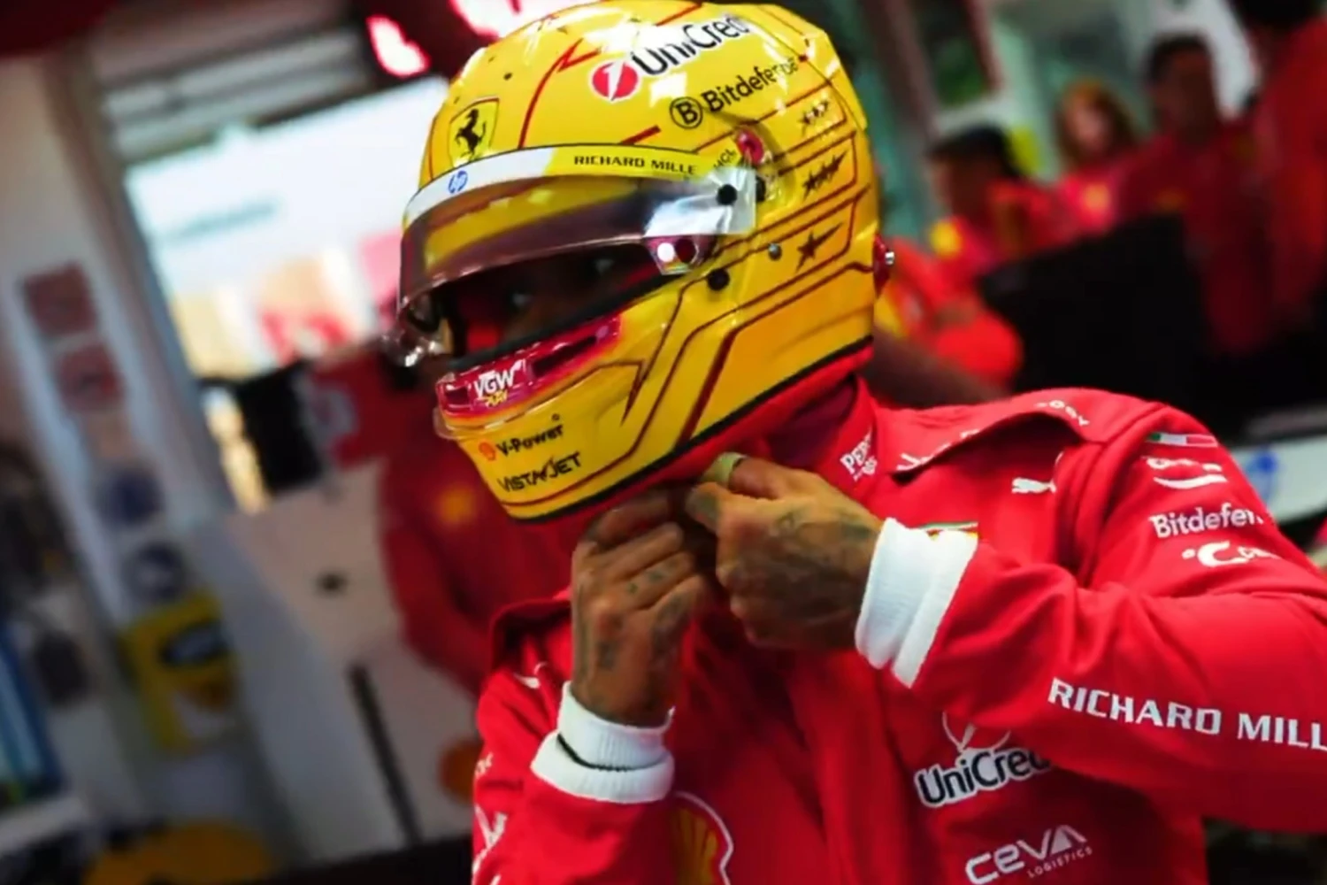 Lewis Hamilton shows off his new helmet in Scuderia Ferrari’s red suit